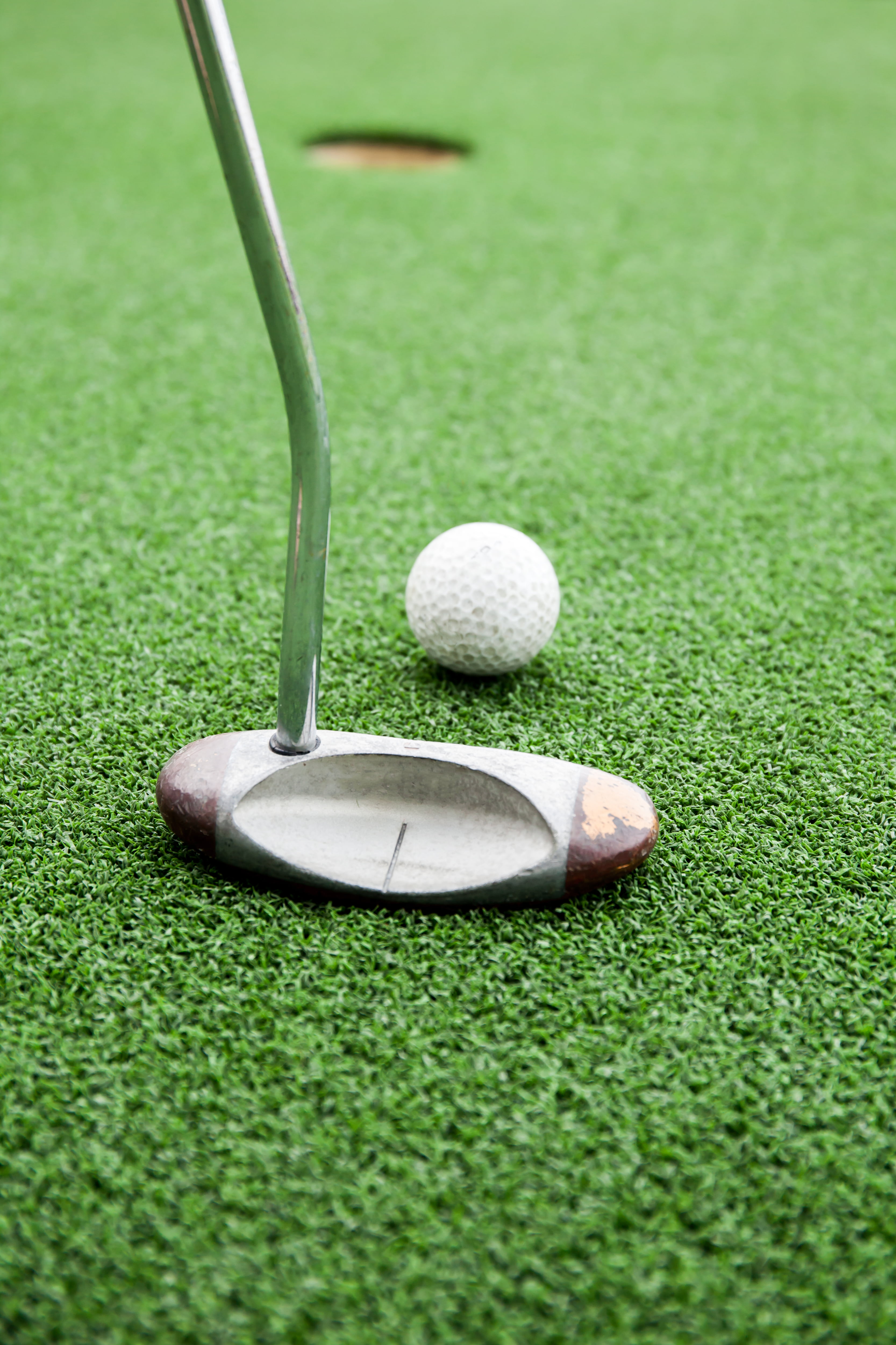 Close-up of golfer playing a golf in green grass field